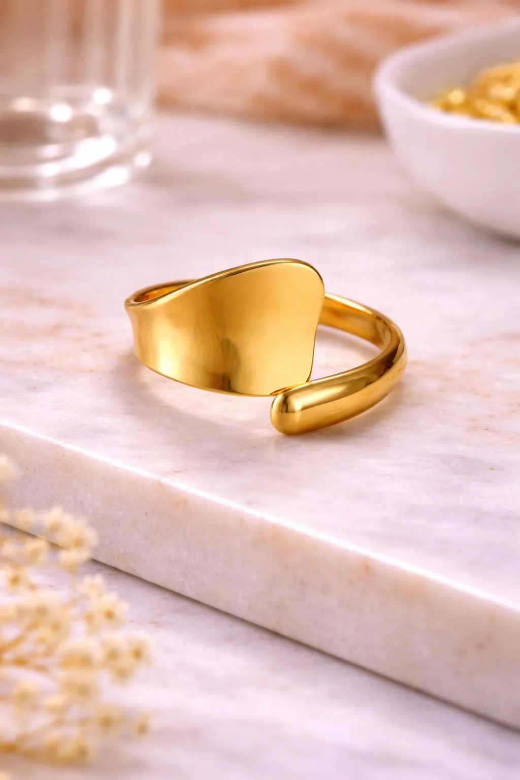 Anillo Cala doradode acero inoxidable ajustable sobre escaparate de marmol