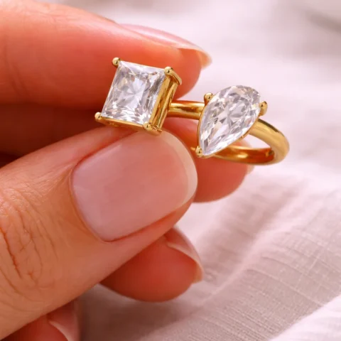 anillo dalia dorado con doble piedra circonita sujetado con los dedos