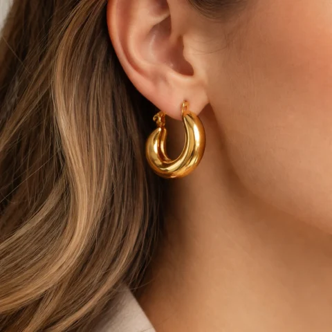 Pendientes Duna dorados puestos en oreja estilo aro grueso elegante