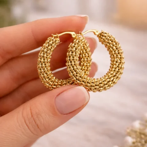 aros dorados Nexus tipo eslabón sostenidos en la mano