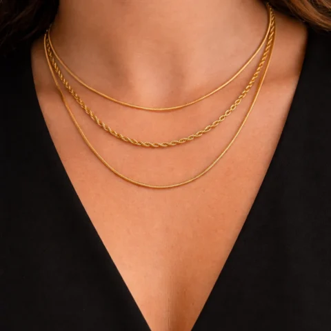 Collar Nova Triple dorado con tres cadenas puesto en cuello con camisa negra