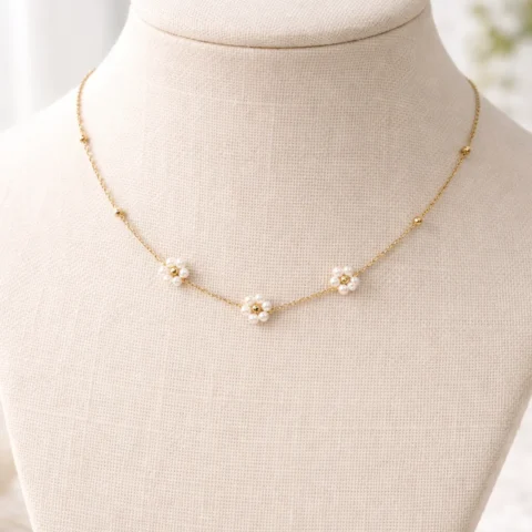 Collar Aura Bloom dorado con flores de perlas sobre busto