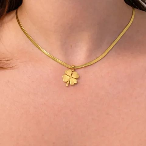 Collar trébol dorado puesto en cuello mujer elegante joya minimalista