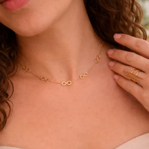 collar Infinia dorado puesto en cuello con diseño infinito elegante