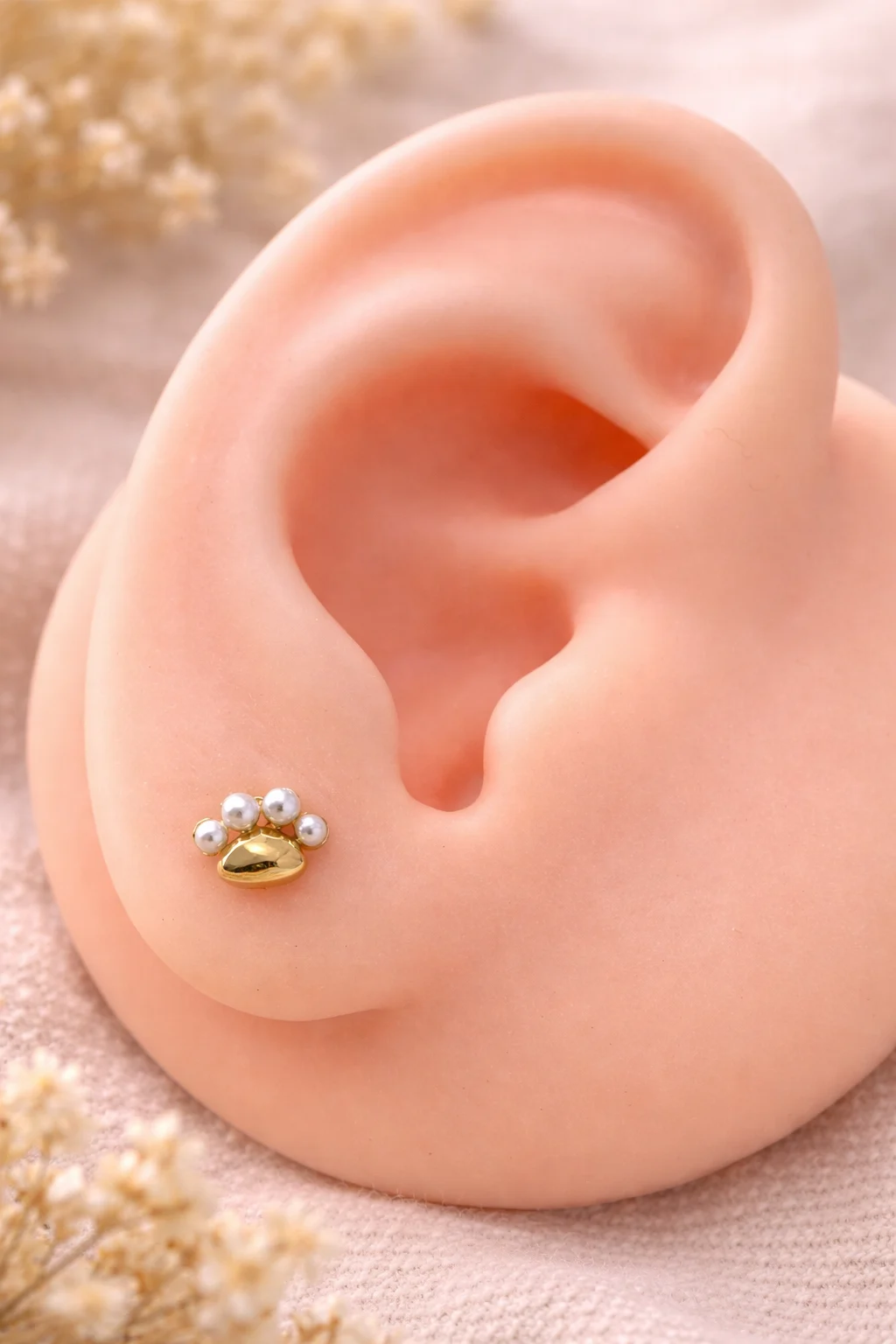 Pendiente huella con perlas en expositor de oreja fondo natural