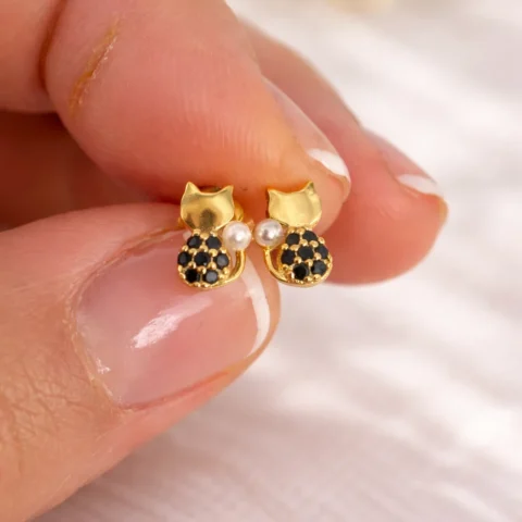 pendientes gato dorado plata 925 con perla y circonitas negras en mano