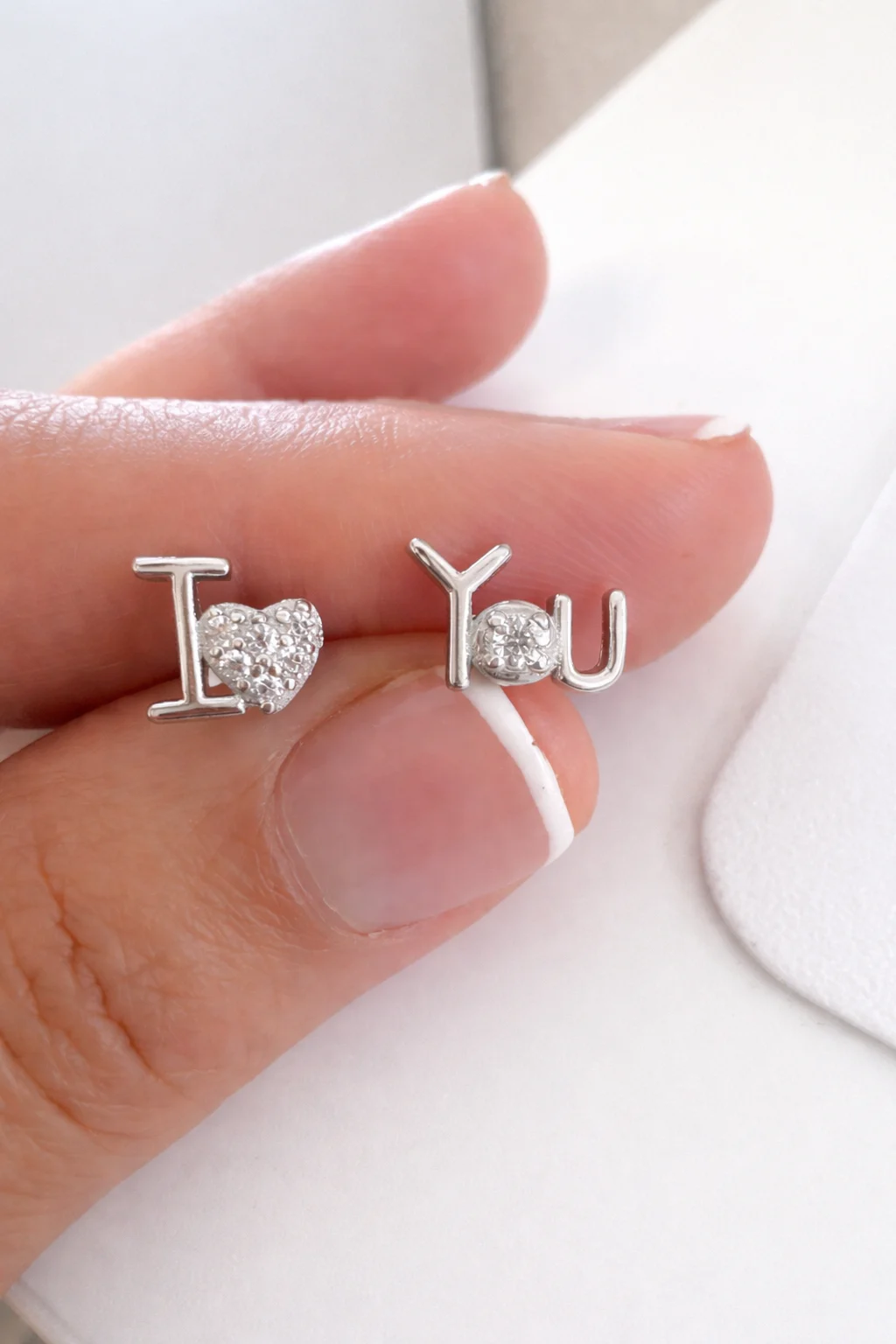 Pendientes Mini Dúo Love de plata de ley 925 sostenidos en mano