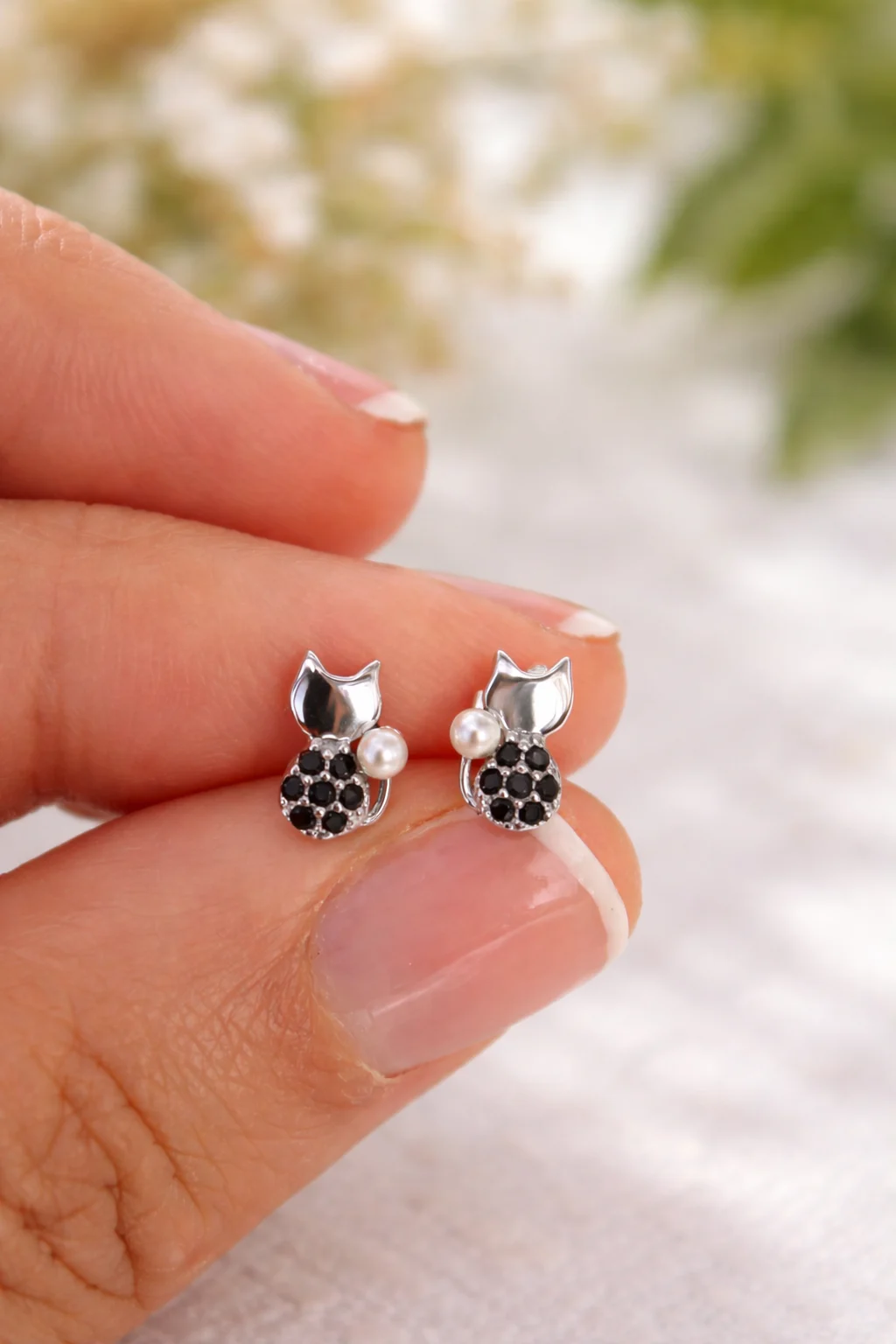 Pendientes mini gato plata 925 con circonitas negras y perla en mano