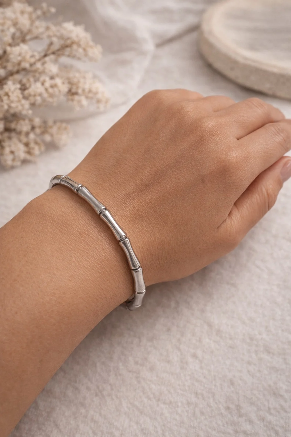 Pulsera Velia plateada de acero inoxidable con diseño bambú puesta en la muñeca.