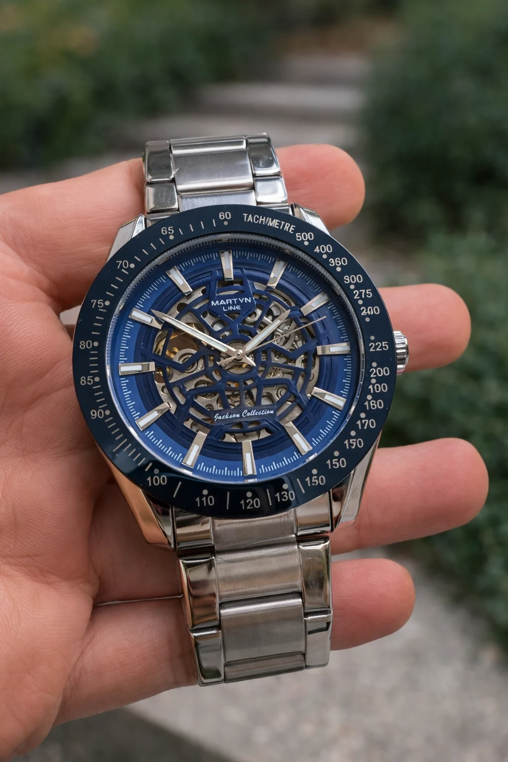 Reloj automático Martyn Line Horizon Blue con esfera skeleton y correa de acero inoxidable sostenido en la mano